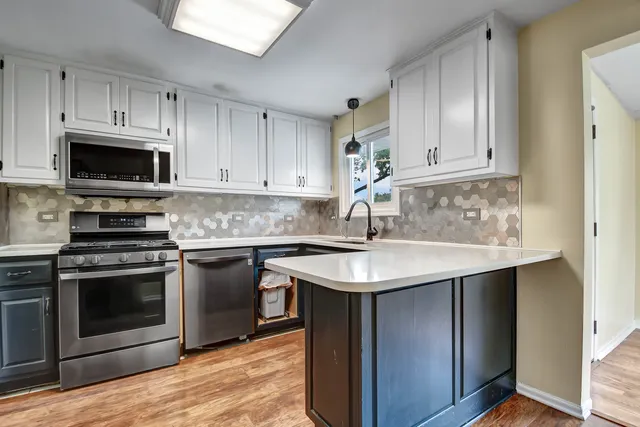 a kitchen with stainless steel appliances granite countertop a sink stove and microwave