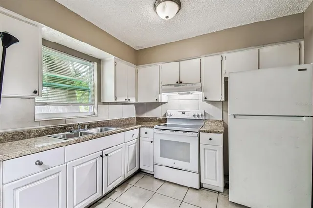 a kitchen with a white cabinets and white appliances