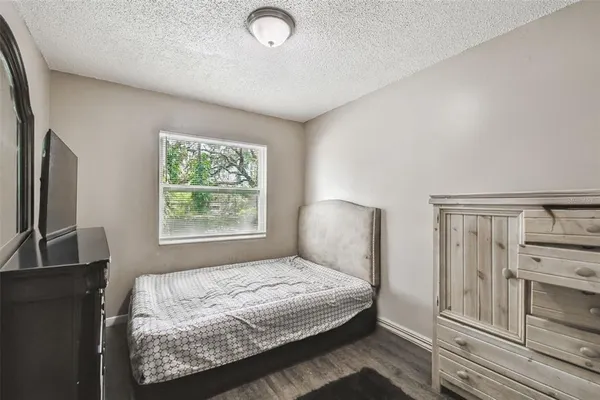 a bedroom with a bed and a flat tv screen on a dresser