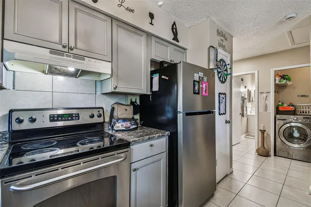 a kitchen with stainless steel appliances granite countertop a refrigerator and a stove