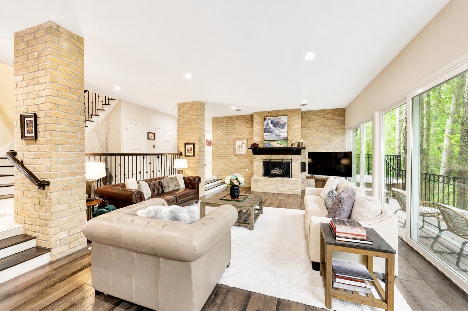 201 Vanderpool Lane, Unit 130 Houston, TX 77024 - Photo 4 of 41 Floor-to-ceiling brick walls and matching columns help define the living room and add a great textural contrast to the walls, floors and lush landscape beyond.