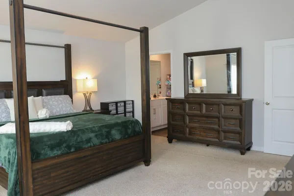 a spacious bedroom with a bed and a dresser