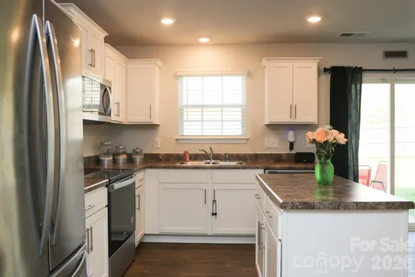 a kitchen with stainless steel appliances granite countertop a sink a stove and a refrigerator
