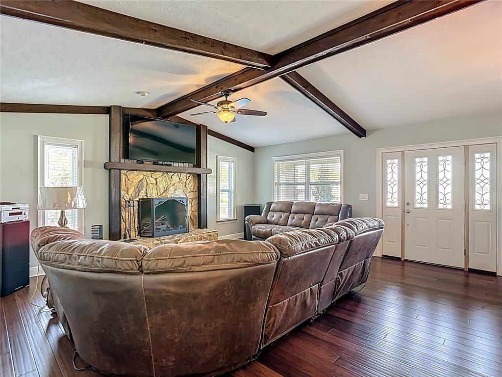 5904 Springrun Court Holiday, FL 34690 - Photo 12 of 79 a living room with furniture a fireplace and a floor to ceiling window