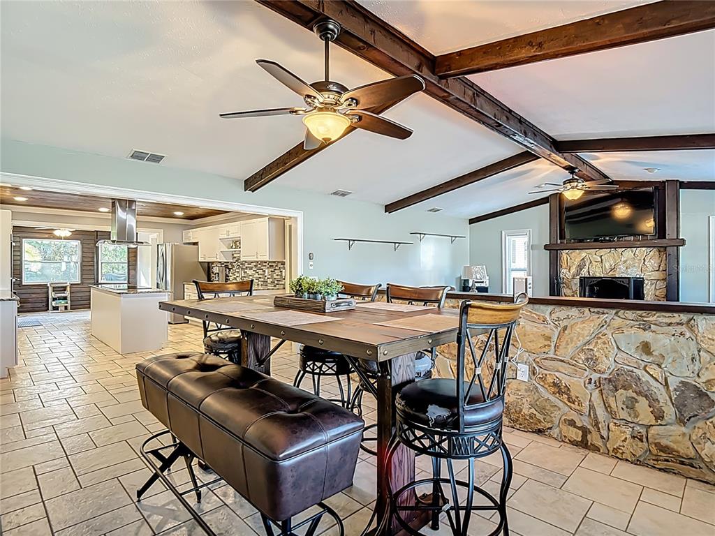 5904 Springrun Court Holiday, FL 34690 - Photo 17 of 79 a dining hall with stainless steel appliances kitchen island granite countertop a table and chairs