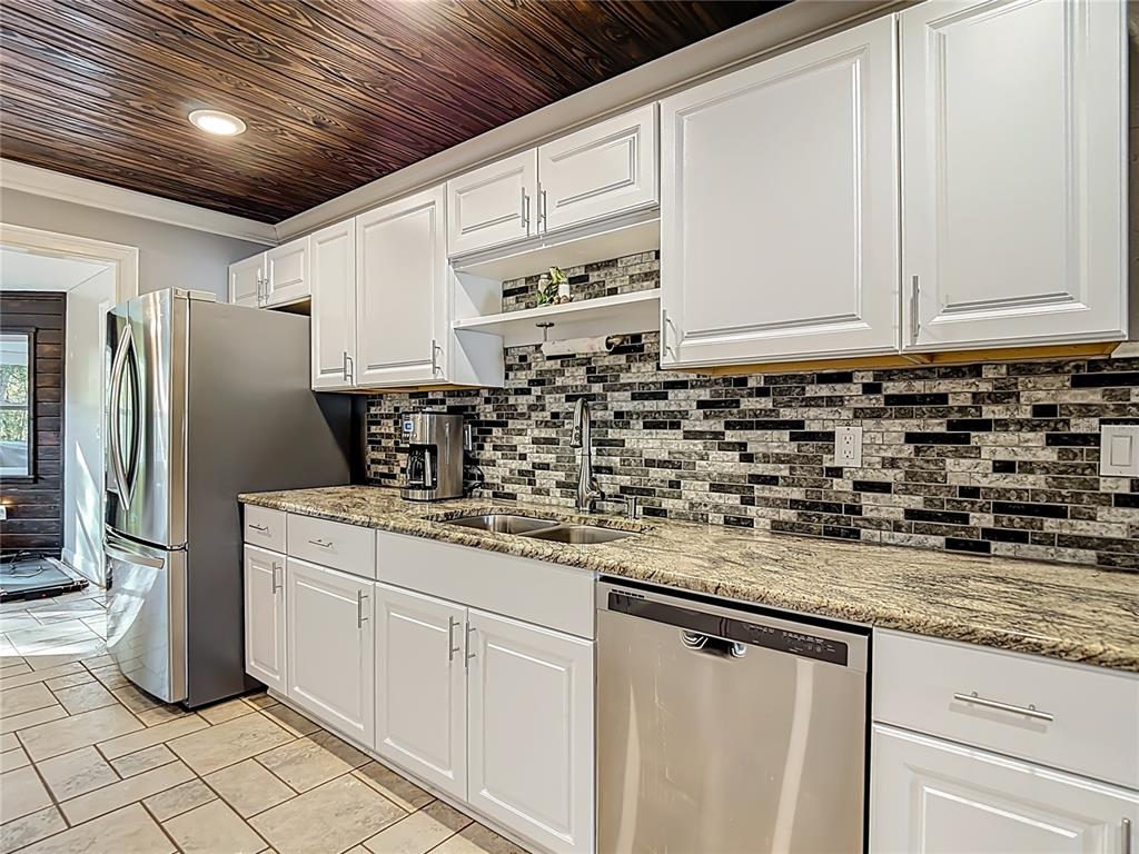 5904 Springrun Court Holiday, FL 34690 - Photo 23 of 79 a kitchen with granite countertop a sink a stove and a refrigerator