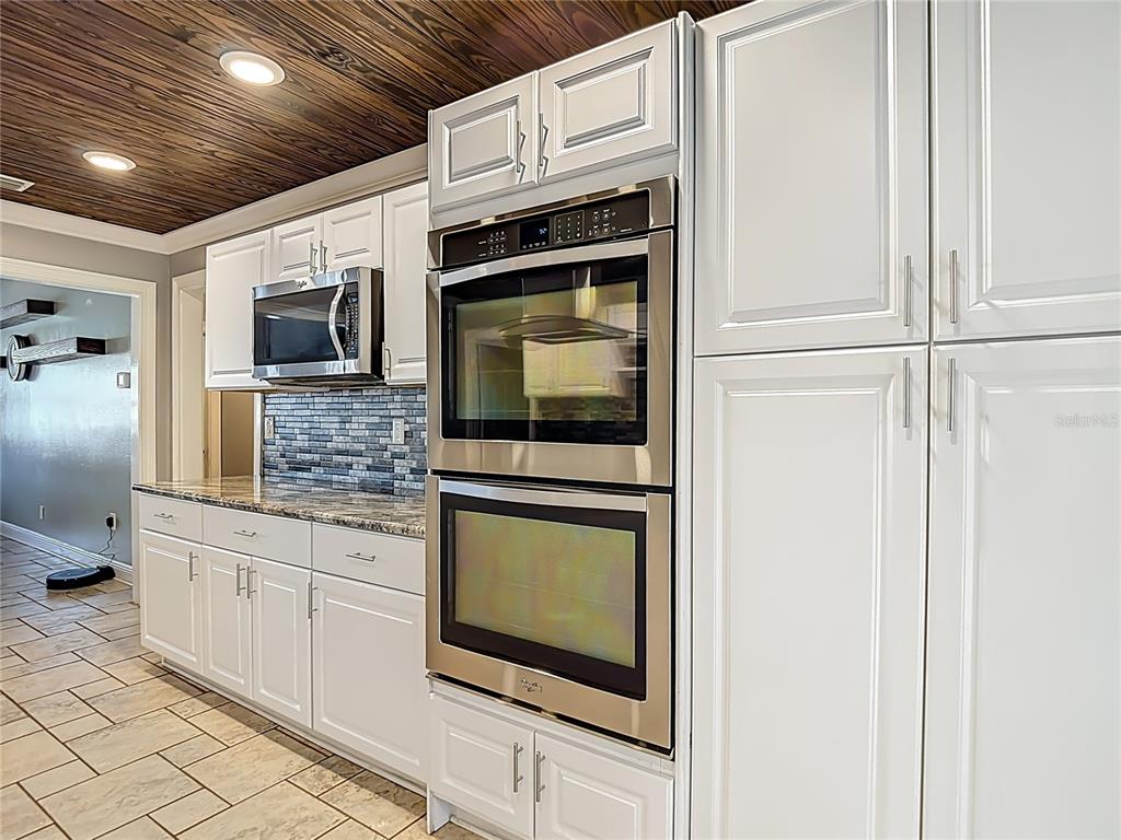 5904 Springrun Court Holiday, FL 34690 - Photo 24 of 79 a kitchen with stainless steel appliances granite countertop a stove microwave and refrigerator