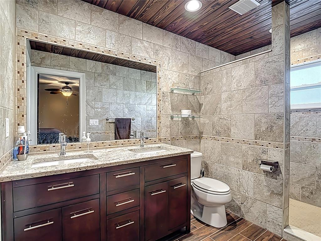 5904 Springrun Court Holiday, FL 34690 - Photo 46 of 79 a bathroom with a granite countertop sink toilet and shower
