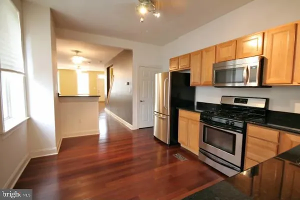 a kitchen with stainless steel appliances granite countertop a stove a refrigerator and a microwave