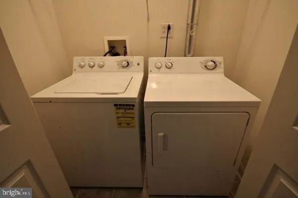 en empty room with a chandelier fan and windows