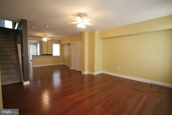 an empty room with wooden floor and a bathroom