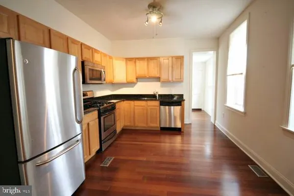 an empty room with wooden floor and window
