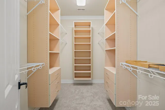 a view of walk in closet with empty racks