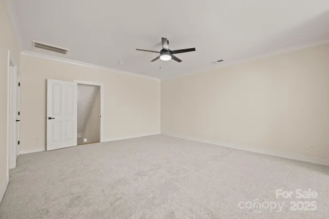 an empty room with a ceiling fan and a window