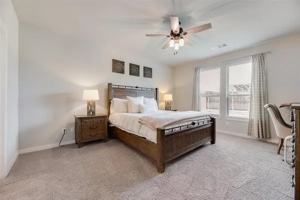 a bed sitting in a spacious bedroom next to a window