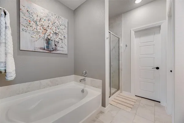 a spacious bathroom with a bathtub and shower