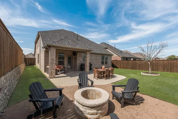 a view of a house with backyard sitting area and furniture