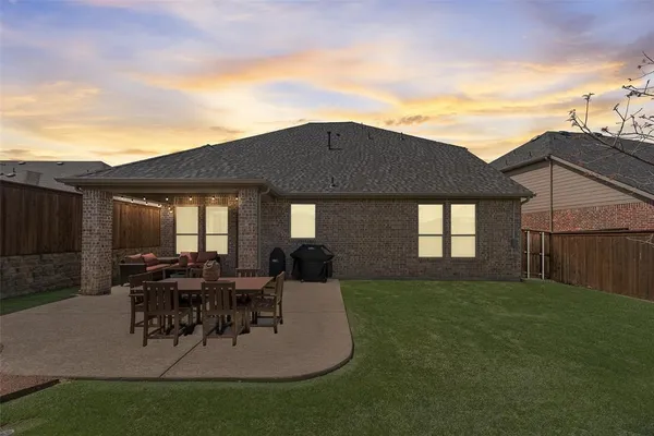 a backyard of a house with table and chairs