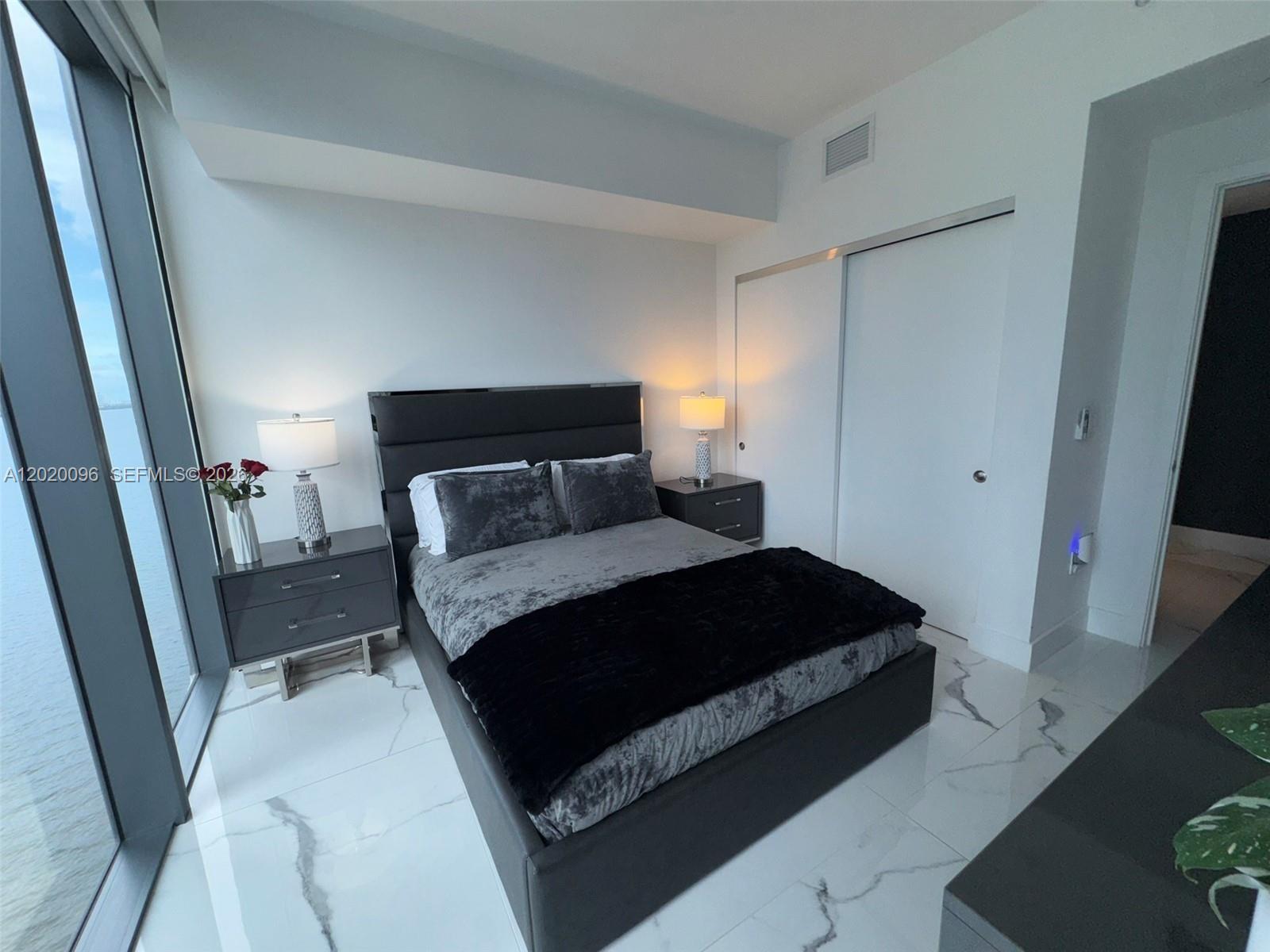 788 Northeast 23rd Street, Unit 1202 Miami, FL 33137 - Photo 29 of 64 a bedroom with a bed and a mirror