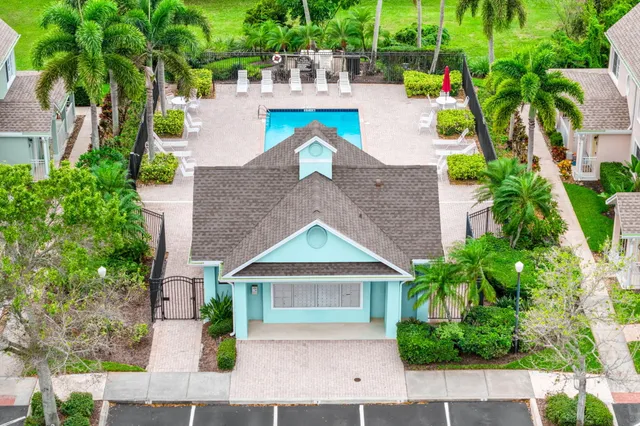 a view of a swimming pool with a lounge chair and palm trees