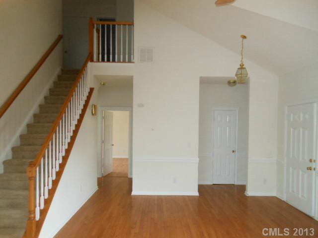 4513 Hyperion Court Charlotte, NC 28216 - Photo 4 of 16 a view of a hallway with wooden floor and staircase