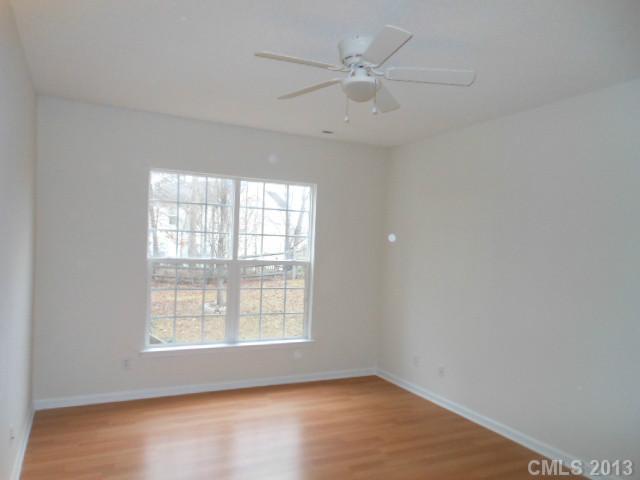 4513 Hyperion Court Charlotte, NC 28216 - Photo 7 of 16 an empty room with wooden floor fan and windows