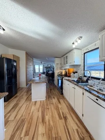 a kitchen with kitchen island a counter space a stove a sink and a refrigerator