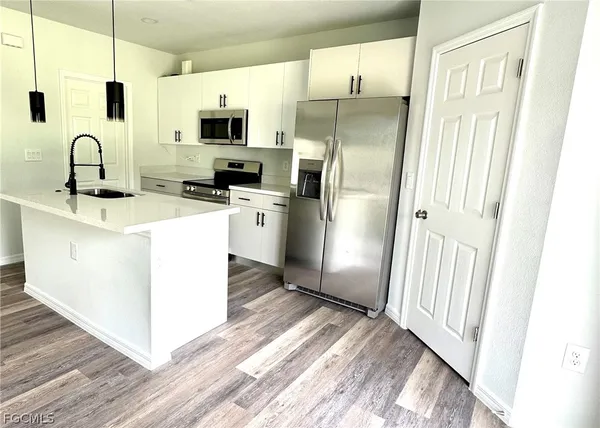 a kitchen with stainless steel appliances a refrigerator sink and microwave
