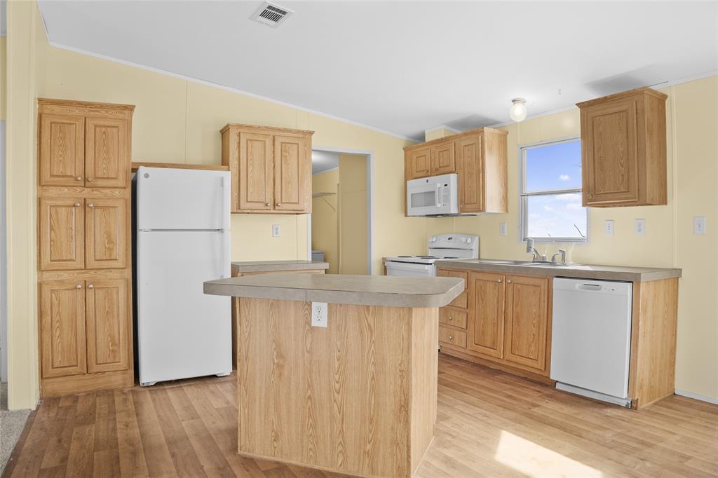 242 Private Road 4732 Rhome, TX 76078 - Photo 11 of 33 a kitchen with stainless steel appliances granite countertop a stove a refrigerator a sink a refrigerator and white cabinets with wooden floor