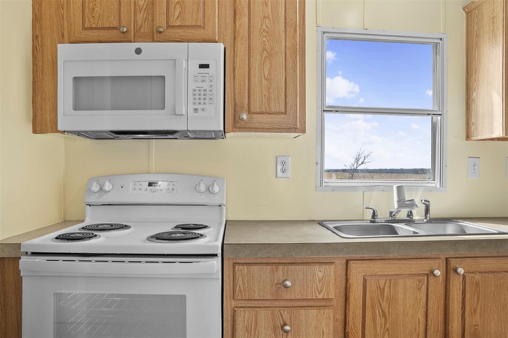 242 Private Road 4732 Rhome, TX 76078 - Photo 13 of 33 a kitchen with a stove and cabinets