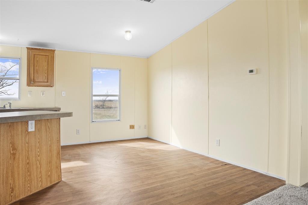242 Private Road 4732 Rhome, TX 76078 - Photo 14 of 33 a view of an empty room with wooden floor and a window