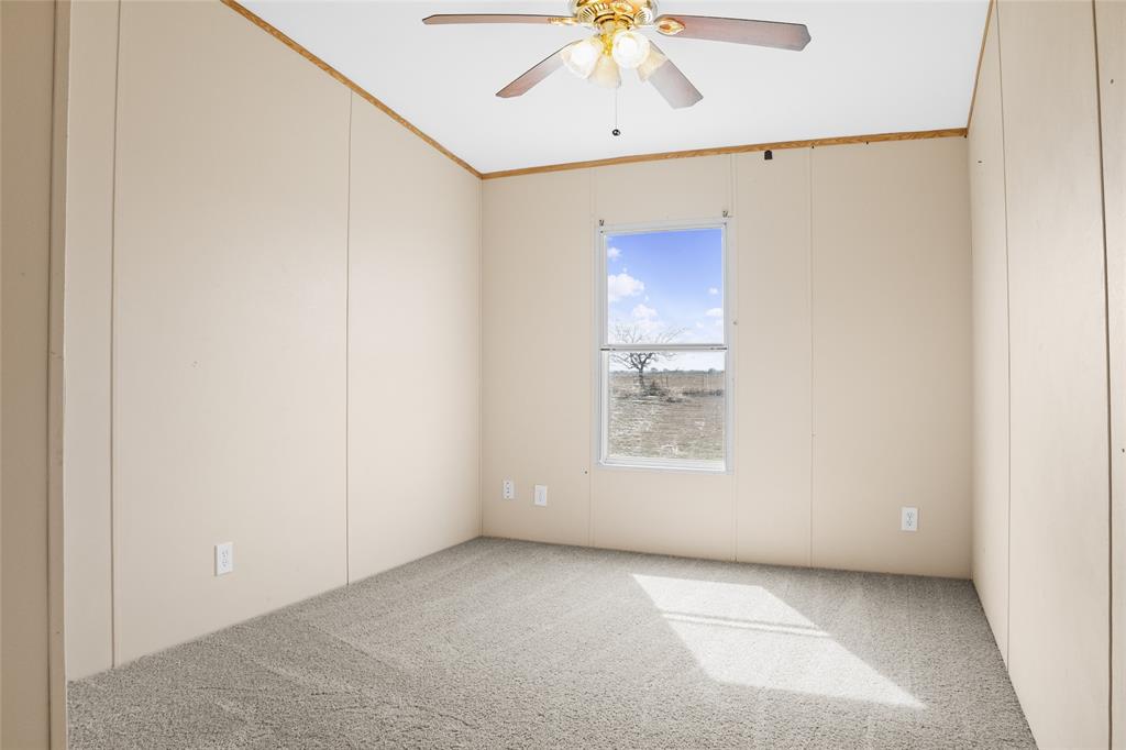 242 Private Road 4732 Rhome, TX 76078 - Photo 19 of 33 an empty room with a window and chandelier fan