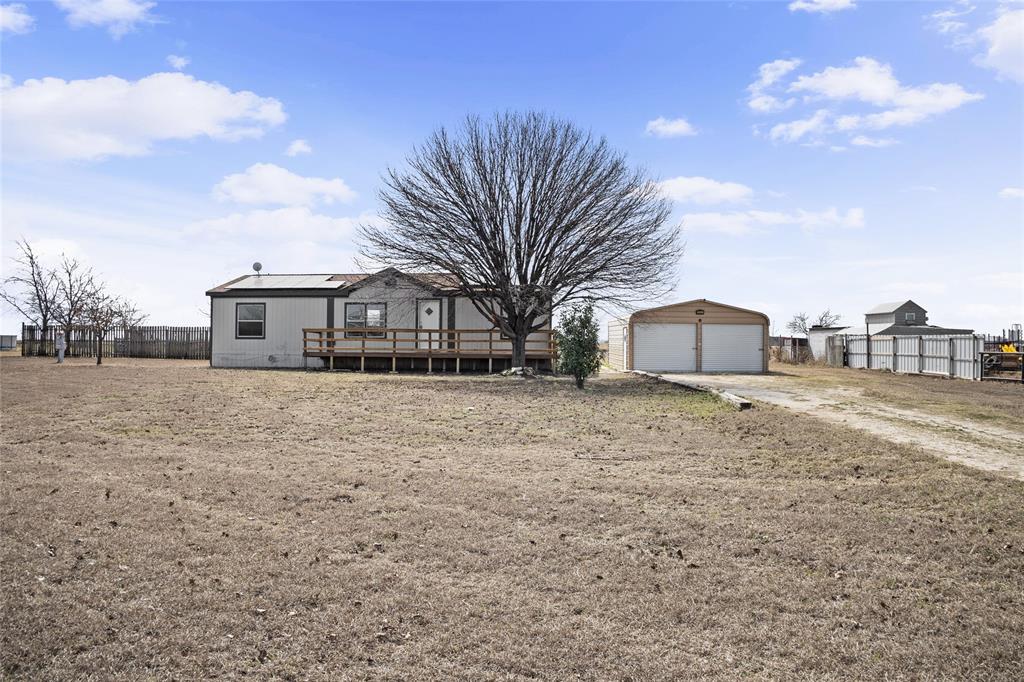242 Private Road 4732 Rhome, TX 76078 - Photo 3 of 33 a front view of a house with a yard and garage