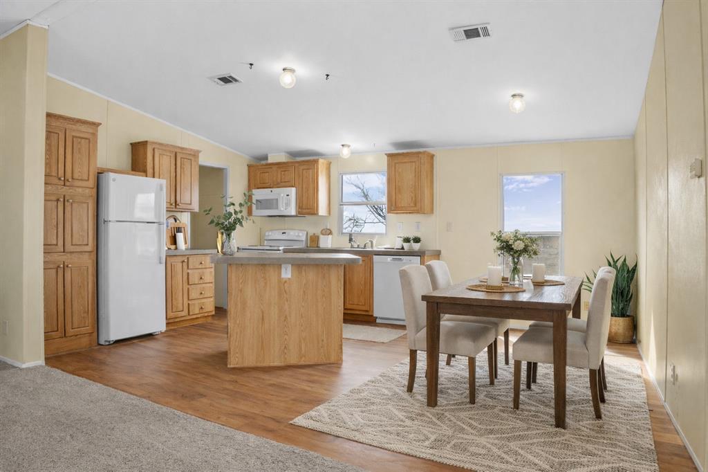 242 Private Road 4732 Rhome, TX 76078 - Photo 9 of 33 a kitchen with a refrigerator a table and chairs in it