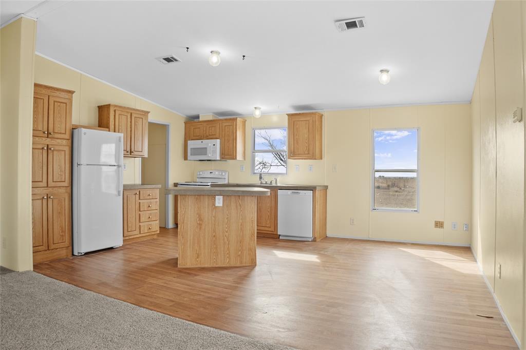 242 Private Road 4732 Rhome, TX 76078 - Photo 10 of 33 a view of a kitchen with a refrigerator wooden cabinets and a refrigerator