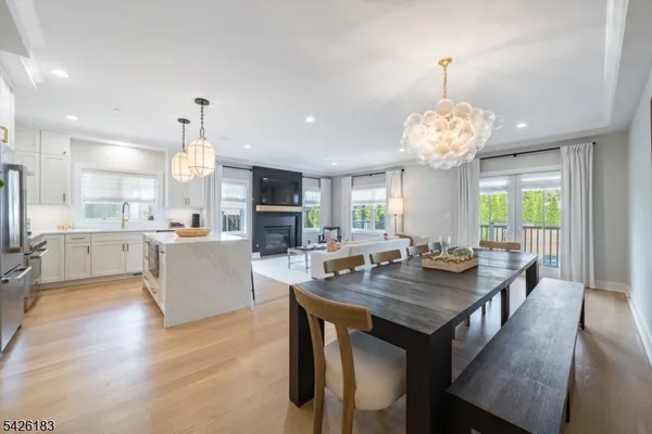 a view of a dining room and livingroom with furniture wooden floor a chandelier