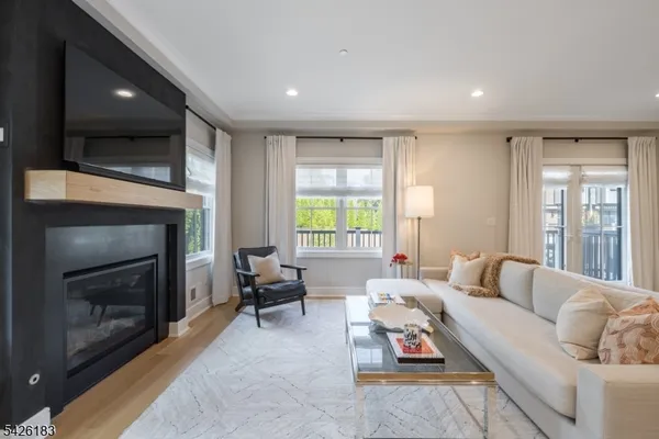 a living room with furniture kitchen view and a wooden floor