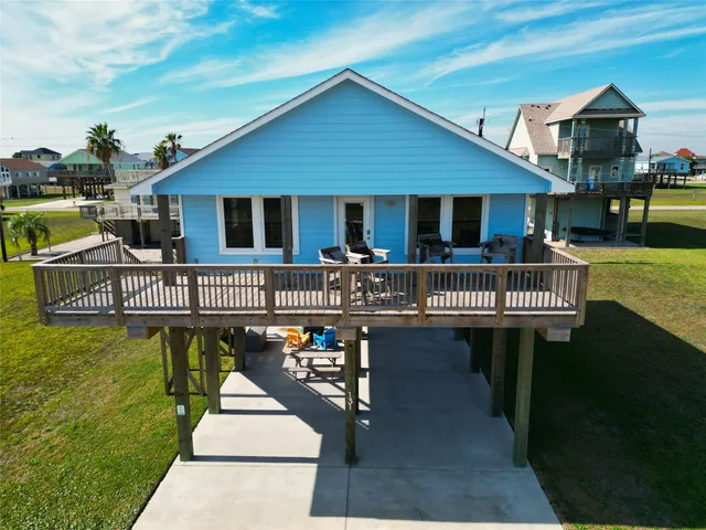a front view of a house with swimming pool table and chairs