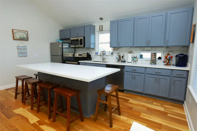 a kitchen with stainless steel appliances granite countertop a table chairs microwave and sink