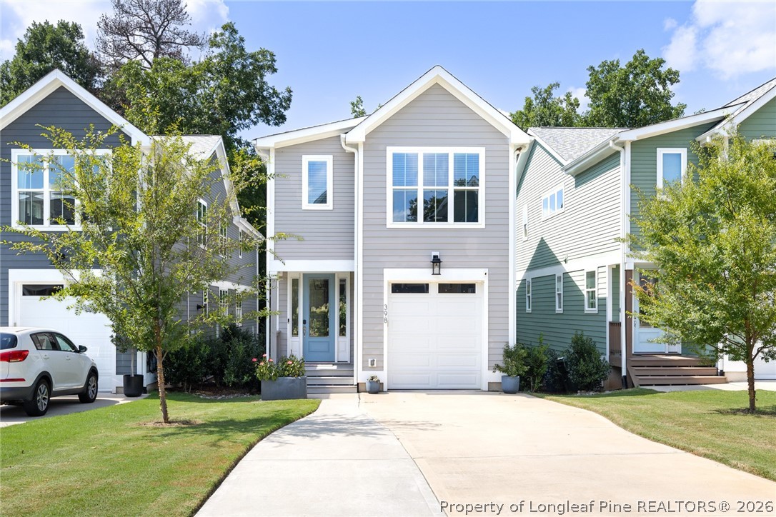 a front view of a house with a yard and trees
