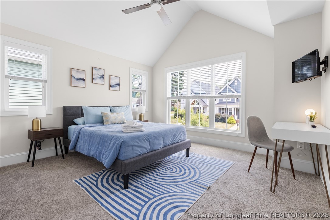 398 Carolina Avenue Raleigh, NC 27606 - Photo 24 of 50 a spacious bedroom with a bed a table and chair with the front door