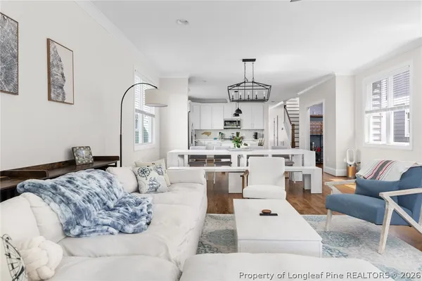 a kitchen with stainless steel appliances a refrigerator a stove a sink dishwasher and a dining table with wooden floor