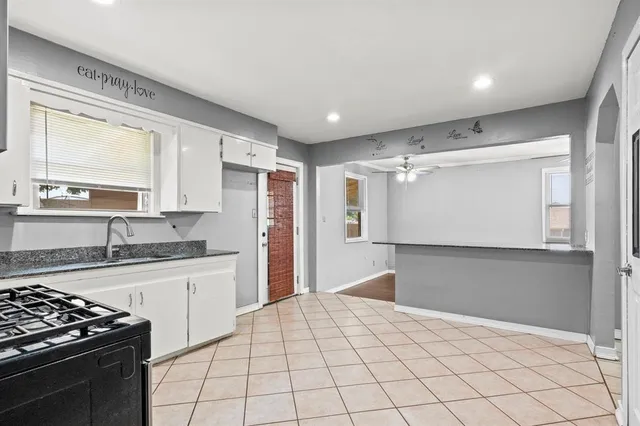 a kitchen with granite countertop a sink stainless steel appliances and cabinets