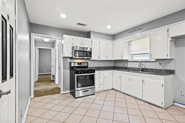 a kitchen with stainless steel appliances granite countertop a refrigerator and a stove top oven