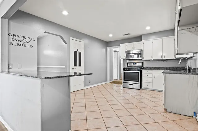 a kitchen with stainless steel appliances a refrigerator and microwave