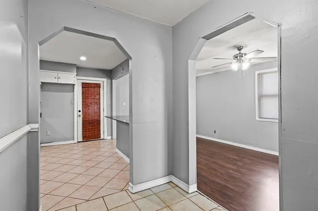a view of a hallway with closet and a chandelier fan