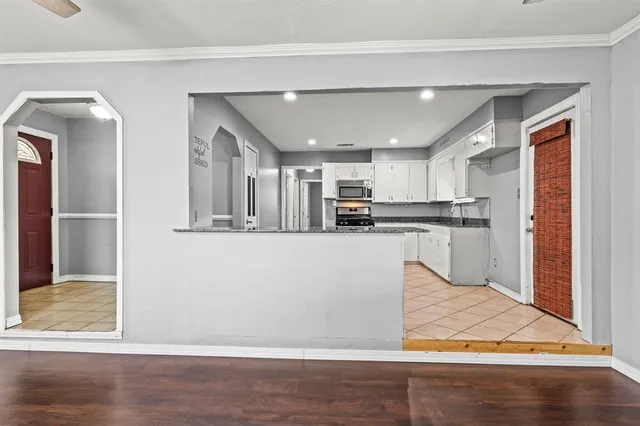 a view of a kitchen with wooden floor and cabinets