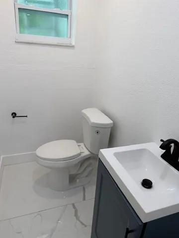 a bathroom with a sink a toilet and mirror