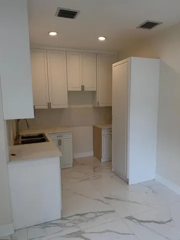 a kitchen with a refrigerator sink and cabinets