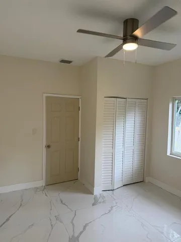 an empty room with fan and entrance